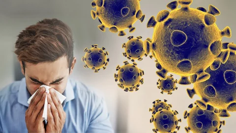 Sneezing man in background of blown up viruses